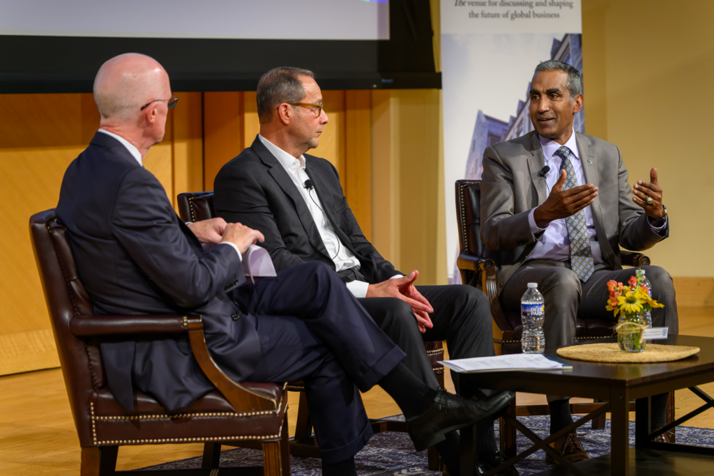 Leaders speak with each other, sitting in chairs on stage.