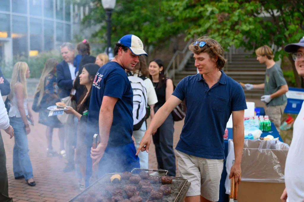 Students, faculty, and staff at a barbecue cookout in front of Hariri
